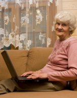 Older woman on couch with laptop